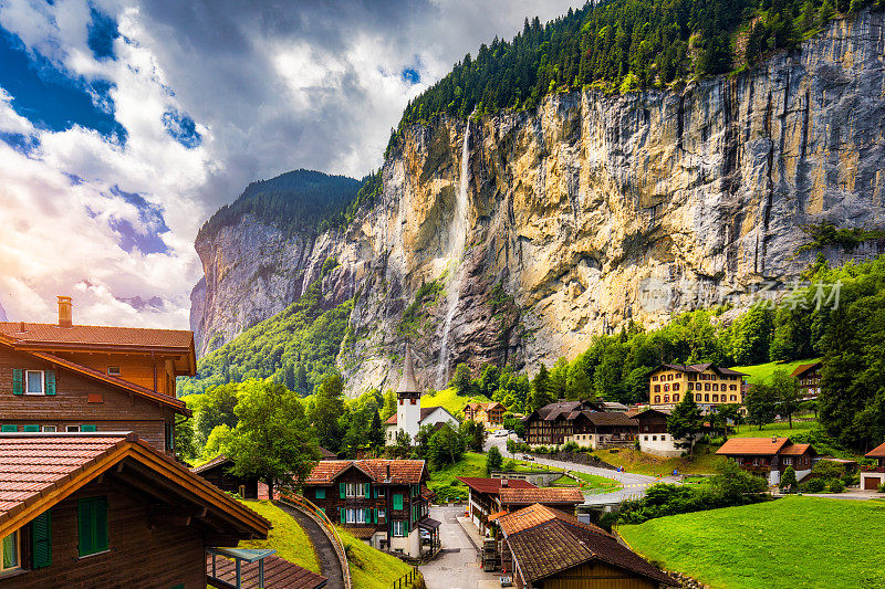 高山旅游村庄Lauterbrunnen令人惊叹的夏季景观，著名的教堂和Staubbach瀑布。地点:Lauterbrunnen村，Berner Oberland，瑞士，欧洲。